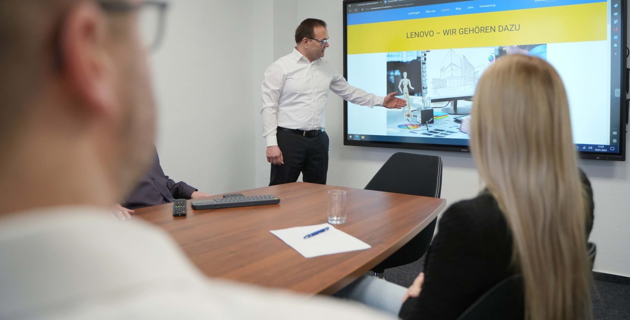 Situationsbild Michael Zimmermann präsentiert die Zimmermann Seite in einem Meetingraum auf einem Smartboard.